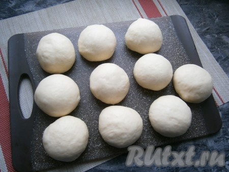 Тесто разделить на 10 частей, каждая по 90-100 грамм, но лучше сделать 9 частей, так как на противень помещается именно столько. Мне пришлось одну булочку выпекать отдельно. Подкатать части теста в шарики.
