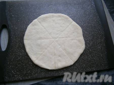 Каждый шарик теста на поверхности, припылённой мукой, раскатать в лепёшку диаметром около 15-16 см. Шпателем для выравнивания торта или ножом поделить (не разрезая) лепёшку на 8 частей (секторов).
