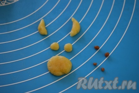 Далее делаем из кусочков теста, оставленных для украшения, глазки, носики, рожки и ушки. Стараемся, чтобы носики, рожки и глазки были другого цвета, чем тело бычка, а ушки можно сделать такого же цвета. В центр глазок выкладываем семена чёрного кунжута.