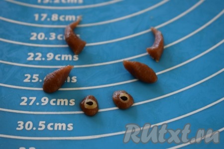 Далее делаем из кусочков теста, оставленных для украшения, глазки, носики, рожки и ушки. Стараемся, чтобы носики, рожки и глазки были другого цвета, чем тело бычка, а ушки можно сделать такого же цвета. В центр глазок выкладываем семена чёрного кунжута.