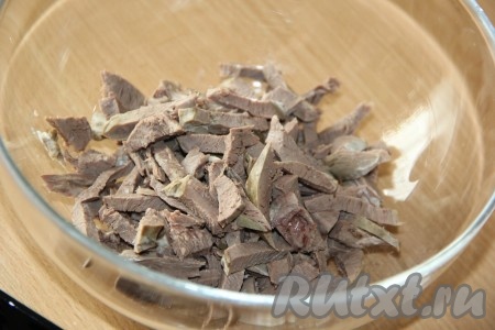 Остывшее свиное сердце достать из бульона и нарезать на тонкие брусочки.
