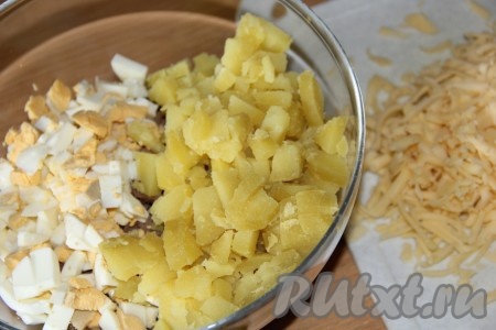 Тщательно вымытый картофель отварить в кожуре до готовности (в течение минут 20-25 с момента закипания воды), затем воду слить, картофелины остудить, очистить, нарезать на небольшие кубики и выложить в салат из яиц и сердца. Натереть на тёрке сыр.