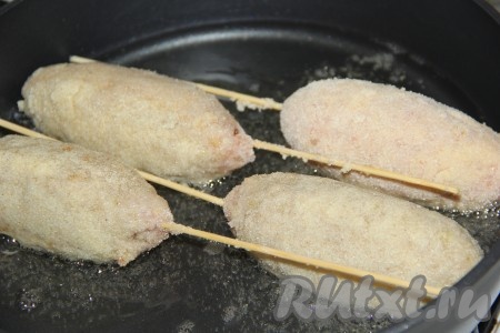 Разогреть в сковороде растительное масло, выложить в него котлеты на шпажках. Масла не жалейте, его должно быть достаточно много.
