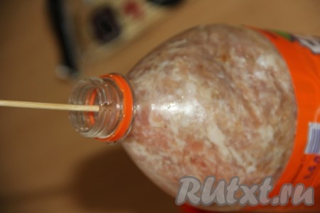 Выложить фарш в часть бутылки с горлышком.&nbsp;Другую часть разрезанной бутылки вставить донышком в бутылку, как пресс для фарша. Вставить в горлышко бутылки шпажку.&nbsp;
