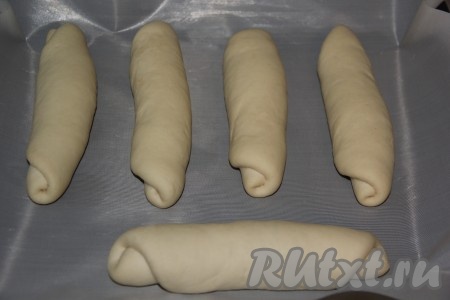 Свернуть круг в плотный и длинный рулетик. Выложить заготовки для булочек на противень, застеленный пергаментом (или тефлоновым ковриком). Оставить для расстойки на 1 час.
