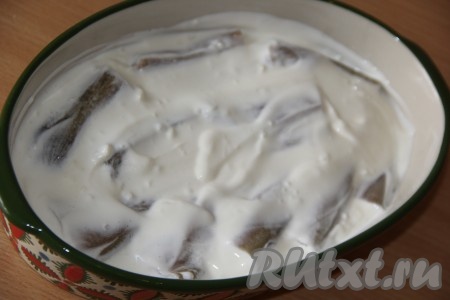 Смазать рыбку сверху смесью сметаны и чеснока.
