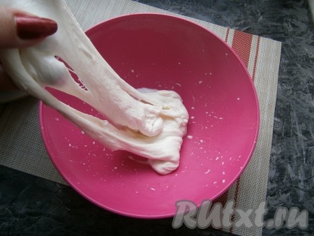 Далее сыворотку нагреть на газу приблизительно до 70-75 градусов (над сывороткой должен появиться пар), всыпать соль, перемешать. Опустить ком сыра в горячую сыворотку, дать прогреться несколько секунд, а затем его нужно достать из сыворотки, выложить в миску и руками (очень горячо, можете надеть толстые перчатки) растягивать сыр. Как только он перестанет тянуться, сложить его в шар и снова поместить его в сыворотку, нагретую до 70-75 градусов, на несколько секунд. Затем снова нужно растягивать в миске. Таким образом растягивать сыр, прогревая его, 3-4 раза и складывая в шар.