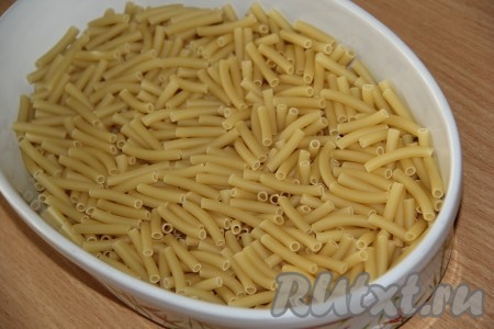 В жаропрочную форму высыпать сухие макароны.