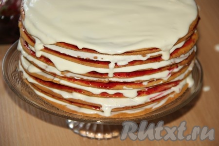 Теперь можно приступать к сборке медовика. Несколько коржей нужно отложить в сторону (они потребуются для обсыпки торта). Первый корж медовика смазать кремом, сверху выложить второй корж, смазать ягодной массой, выложить следующий корж, смазать кремом. Таким образом собрать весь торт, чередуя коржи, смазанные клюквенной массой, и коржи, смазанные кремом. Верхний корж должен быть смазан кремом.
