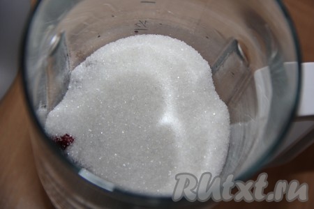 В чашу блендера поместить клюкву, 100 грамм сахара и 3 столовые ложки горячей воды.
