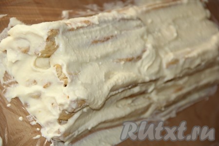 Выложить полоски слоёного теста, щедро смазывая их кремом со всех сторон. Пару полосок теста (без крема) оставить на обсыпку торта (для крошки).
