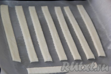 Выложить полоски на некотором расстоянии друг от друга на противень, застеленный пергаментом (или тефлоновым ковриком).
