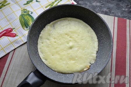 Перед жаркой первого блина сковороду хорошо разогреть, смазав её немного растительным маслом (буквально на это потребуется несколько капель масла). Налить 2-3 столовые ложки теста в сковороду, распределить его равномерно по всему дну. Жарить блин на среднем огне до румяности с двух сторон, затем переложить на тарелку. А на сковороду влить ещё 2-3 столовые ложки теста (сковороду перед жаркой второго и последующего блинов маслом можно не смазывать, ведь масло входит в состав теста). Таким образом пожарить все блинчики до румяности. Помните, чтобы у вас не было проблем с переворачиванием блинов, жарьте их на специальной сковороде или на хорошей, проверенной обычной сковороде с антипригарным покрытием.
