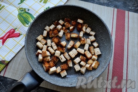 Довести суп-пюре из тыквы с плавленным сыром до кипения при постоянном помешивании и снять с огня. Для приготовления сухариков нарезать хлеб на маленькие кубики и обжарить на сухой сковороде на среднем огне до румяности со всех сторон.
