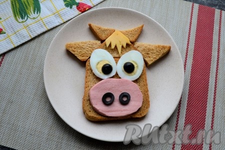 Все подготовленные части выложить на мордочку из хлеба.