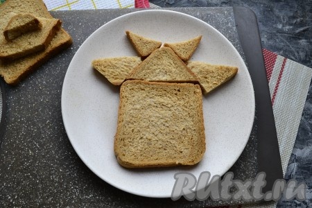 На тарелке собрать все детали хлеба в виде морды бычка (как на фото).
