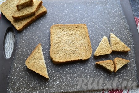 Яйцо отварить заранее в течение 10 минут с момента закипания воды, затем после остывания очистить его. Подготовить детали для бутерброда: один ломтик-квадрат тостового хлеба оставить целым, из другого (может понадобиться и третий) отрезать один треугольник побольше, 2 - средних и ещё 2 треугольничка поменьше.
