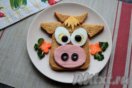 Украсить бутерброд можно цветочками из моркови и зеленью.