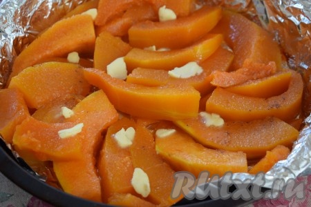 Тыкву посыпаем 3 столовыми ложками сахара (или по вкусу, количество сахара зависит от сладости тыквы). По желанию, можно посыпать тыкву ванильным сахаром и щепоткой корицы, но мой муж любит натуральный аромат и вкус тыквы, поэтому специи и ванильный сахар я не добавляю. Раскладываем сливочное масло между дольками тыквы.
