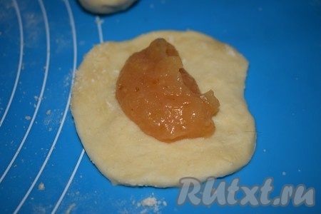 Далее округляем каждый кусочек теста и затем каждый шарик раскатываем в лепёшку. На середину каждой лепёшки кладём половину столовой ложки повидла (я использовала айвовое повидло, вы же можете взять любое, какое вам больше нравится).