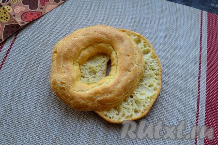 Выпекать кольца из заварного теста в разогретой до 200 градусов духовке 15 минут, а затем при температуре 170 градусов минут 5-7. Достать готовые заварные кольца из духовки, дать им остыть. Каждое остывшее кольцо разрезать пополам горизонтально.