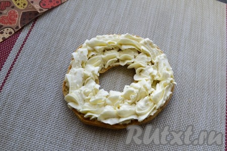 С помощью кондитерского мешка (или просто ложкой) наполнить по кругу нижнюю часть каждого заварного кольца творожным кремом.
