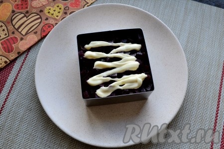 Далее выложить слой свеклы, нарезанной мелкими кубиками, посолить её, немного поперчить, смазать майонезом.
