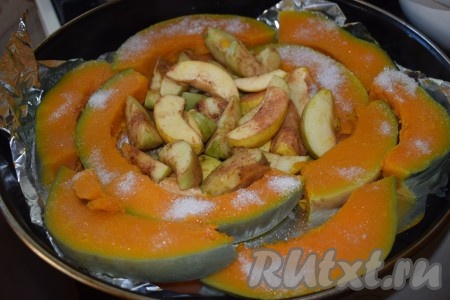 Как только тыква приобретёт прозрачность, вынимаем её из кастрюли и выкладываем по кругу в форму с яблоками. Кусочки тыквы присыпаем 4-5 чайными ложками сахара.
