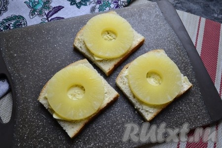 Сверху разместить по целому колечку консервированного ананаса, предварительно обсушив каждое кольцо бумажным полотенцем.
