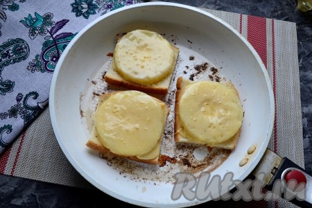 Накрыть сковороду крышкой, огонь уменьшить до минимального. Готовить бутерброды до расплавления сыра (минуты 4).
