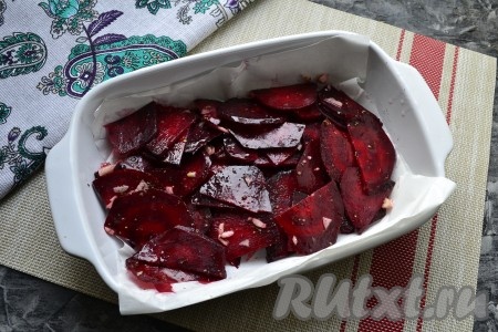 Любую подходящую для запекания форму застелить пергаментом и выложить свеклу, смешанную с чесноком.