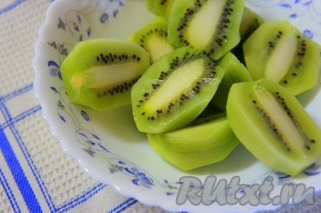 Киви очистить от кожуры и разрезать на половинки.