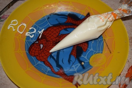 Майонез выкладываем в кулинарный мешочек, от которого отрезаем маленький кончик. Немного тренируемся писать цифры, выдавливая майонез из кулинарного мешочка.