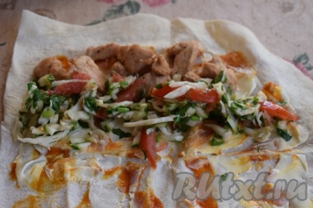 Размазываем кетчуп с майонезом при помощи ложки по поверхности каждой части лаваша, оставляя края лаваша чистыми. На узкий край каждой части лаваша кладём 1/4 часть обжаренного филе индейки, рядом с мясом выкладываем 1/4 часть нарезанных овощей.
