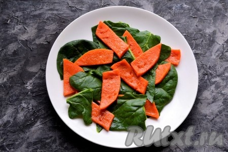 На тарелку поверх шпината разложить ломти запечённой тыквы.