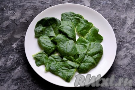 Листья шпината помыть, обсушить. Если листочки крупные, тогда их нужно порвать руками, выложить одним слоем на плоскую тарелку.