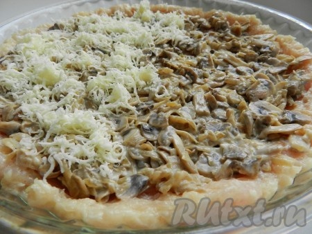 На дно формы для выпечки, смазанной маслом, равномерно выложить куриный фарш, формируя маленькие бортики - это будет корж (основа) нашей пиццы. Поверх фарша выложить остывшие шампиньоны, обжаренные с луком. Грибную начинку сверху посыпать натёртым сыром. Духовку разогреть до 220 градусов, поставить в неё форму с куриной пиццей, выпекать 15-20 минут.