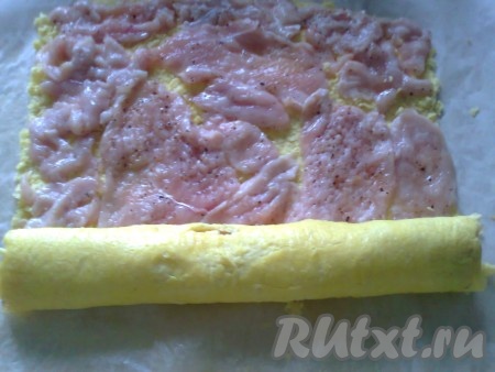 Выкладываем куриное филе на готовый омлет и сворачиваем в рулет.