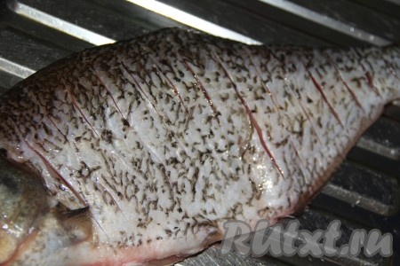Острым ножом сделать глубокие надрезы на всей поверхности рыбы.
