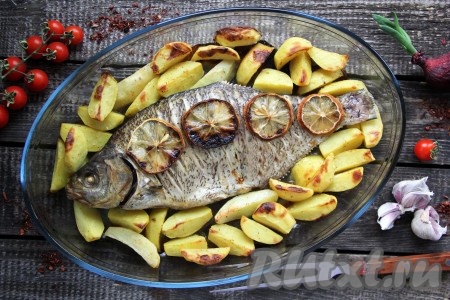 Когда картошка станет достаточно мягкой, достать блюдо из духовки. Подать вкусного, сочного целого леща с аппетитным запечённым картофелем к столу в горячем виде.
