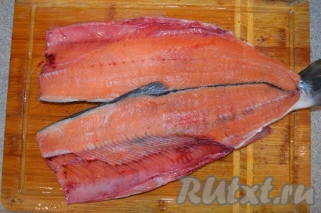 Острым ножом разрезать рыбу по хребту на два филе.
