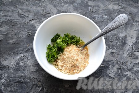 В смесь масла, специй и чеснока всыпать панировочные сухари, добавить измельчённую зелень.
