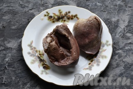 Разрезать сердце пополам, выложить в кастрюлю, полностью залить водой, поставить на огонь, после закипания подсолить воду и, уменьшив огонь, варить часа 1,5. Затем отваренное сердце нужно остудить.