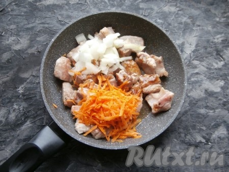 Обжарить мясо, перемешивая, минут 5 на среднем огне. Добавить нарезанный репчатый лук и натёртую на крупной тёрке морковь.
