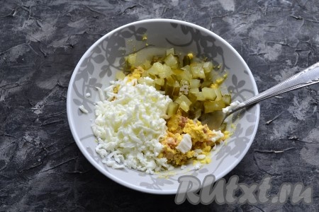 Печень размять вилкой и хорошенько перемешать с желтками, добавить нарезанный мелкими кубиками солёный (или маринованный) огурец и 2/3 натёртых на средней тёрке белков.
