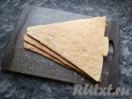 Таким же образом из оставшихся двух частей теста подготовить ещё 2 фигурки ёлки. Пергамент с фигуркой ёлочки переложить на противень. Выпекать медовые коржи в разогретой духовке при температуре 180 градусов около 4-5 минут, дать немного остыть на пергаменте, а затем осторожно его убрать, а коржи полностью остудить.&nbsp;
