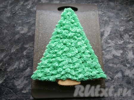 Сверху разместить третий корж. Оставленный крем окрасить зелёным пищевым красителем и отсадить его на верхний корж с помощью той же насадки "звёздочка" только немного под углом. Можно отсаживать крем в разном направлении, можно - в одном.
