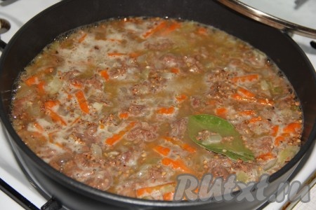 Слегка перемешать гречку с тушёнкой и накрыть сковороду крышкой. Дать воде закипеть, а затем готовить на медленном огне до полного испарения жидкости (на это потребуется минут 15-20).