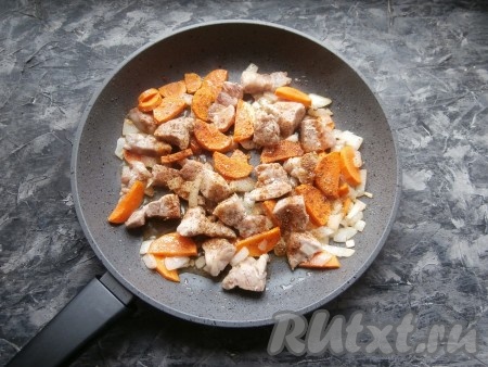 Мясо на достаточно сильном огне обжарить со всех сторон до лёгкой румяности, уменьшить огонь до среднего, добавить нарезанный произвольно лук и нарезанную полукружками морковь, обжарить минуты 3-4, помешивая, посолить немного, посыпать приправой для мяса и чёрным молотым перцем.

