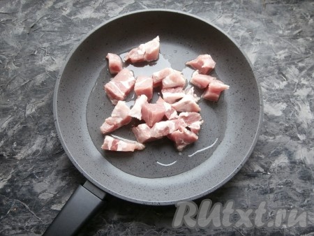 Морковь, чеснок, картофель и лук очистить, удалить семена с плодоножкой из болгарского перца. Свинину нарезать средним кусочками, выложить на сковороду с растительным маслом.